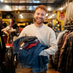 Model wearing minimalist watch with black wristband and white watch face.